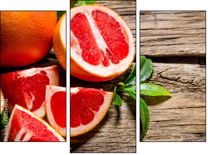 Fresh cut grapefruit with leaves. On wooden table. - Three-piece canvas print, Triptych